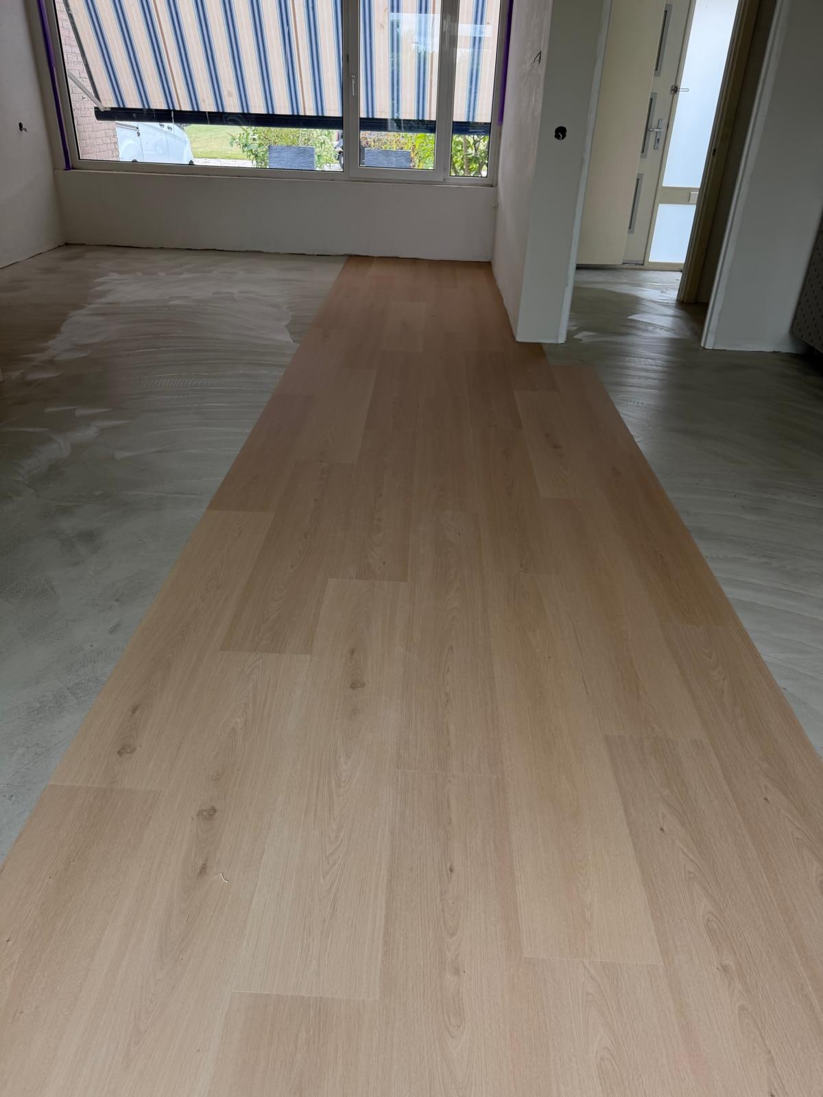 Rechte stroken PVC half gelegd op egaline