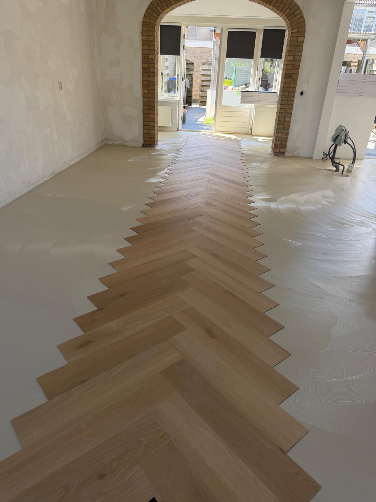 Visgraat PVC die op verse egaline wordt gelegd